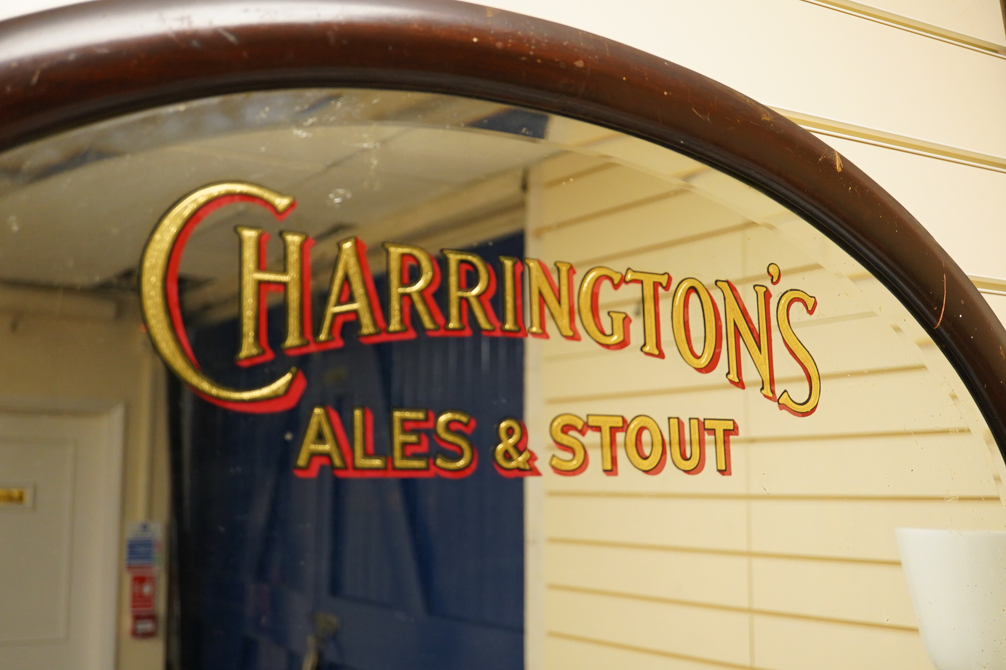 A Charrington's Ale & Stout mahogany framed oval mirror, 86cm wide. Condition - fair